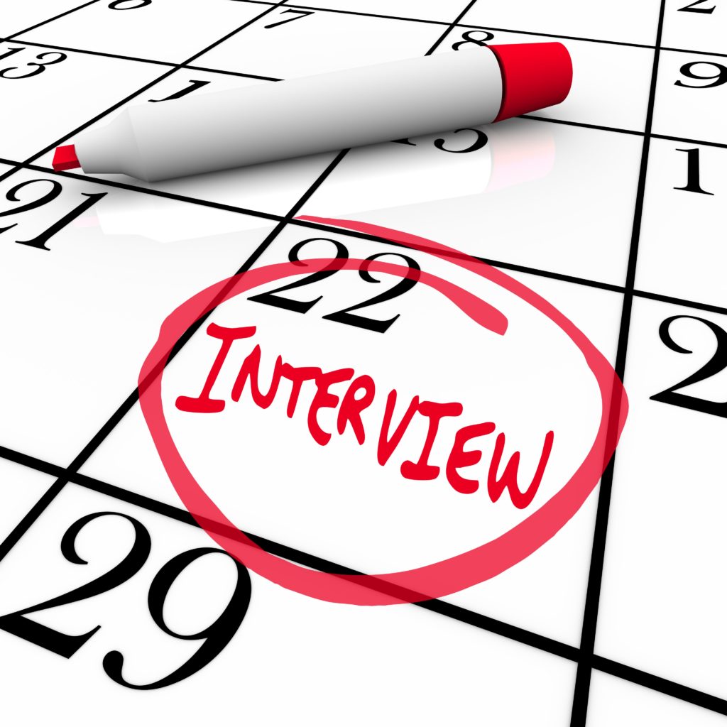 a red market on top of a calendar. one date shows the word "interview" written and circled in red ink.