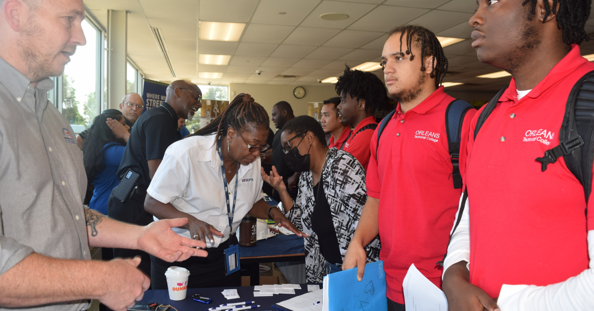 young men speaking to employer at a hiring fair