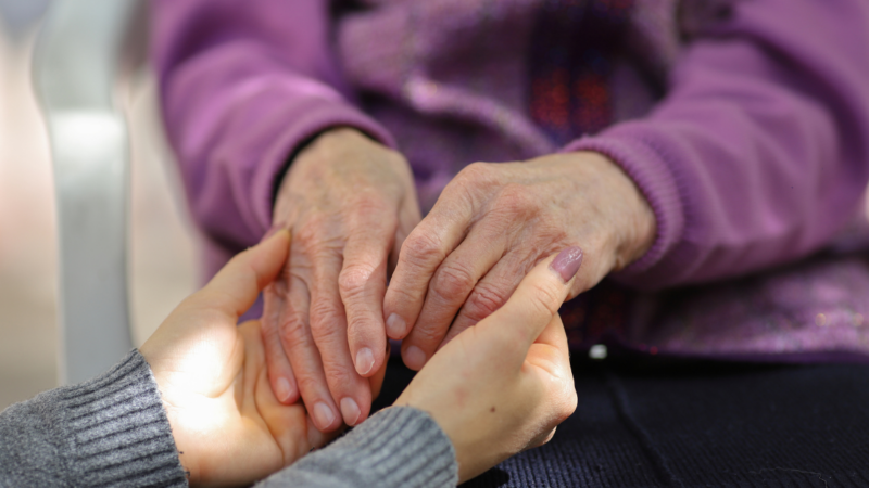 Two people holding hands; up close focus on their hands.