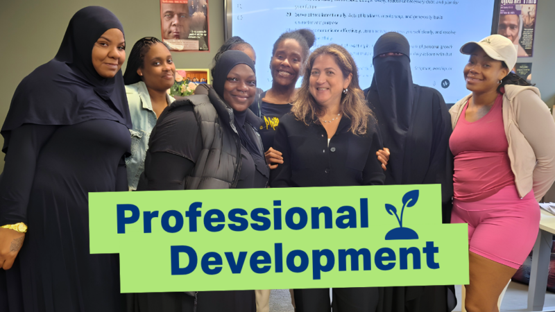 Participants in JEVS Work Ready Foundations Professional Skills class stand with JEVS President & CEO Cynthia Figueroa, smiling for the camera. A light green box at the lower center of the image has the words Professional Development and a plant icon in navy blue font.