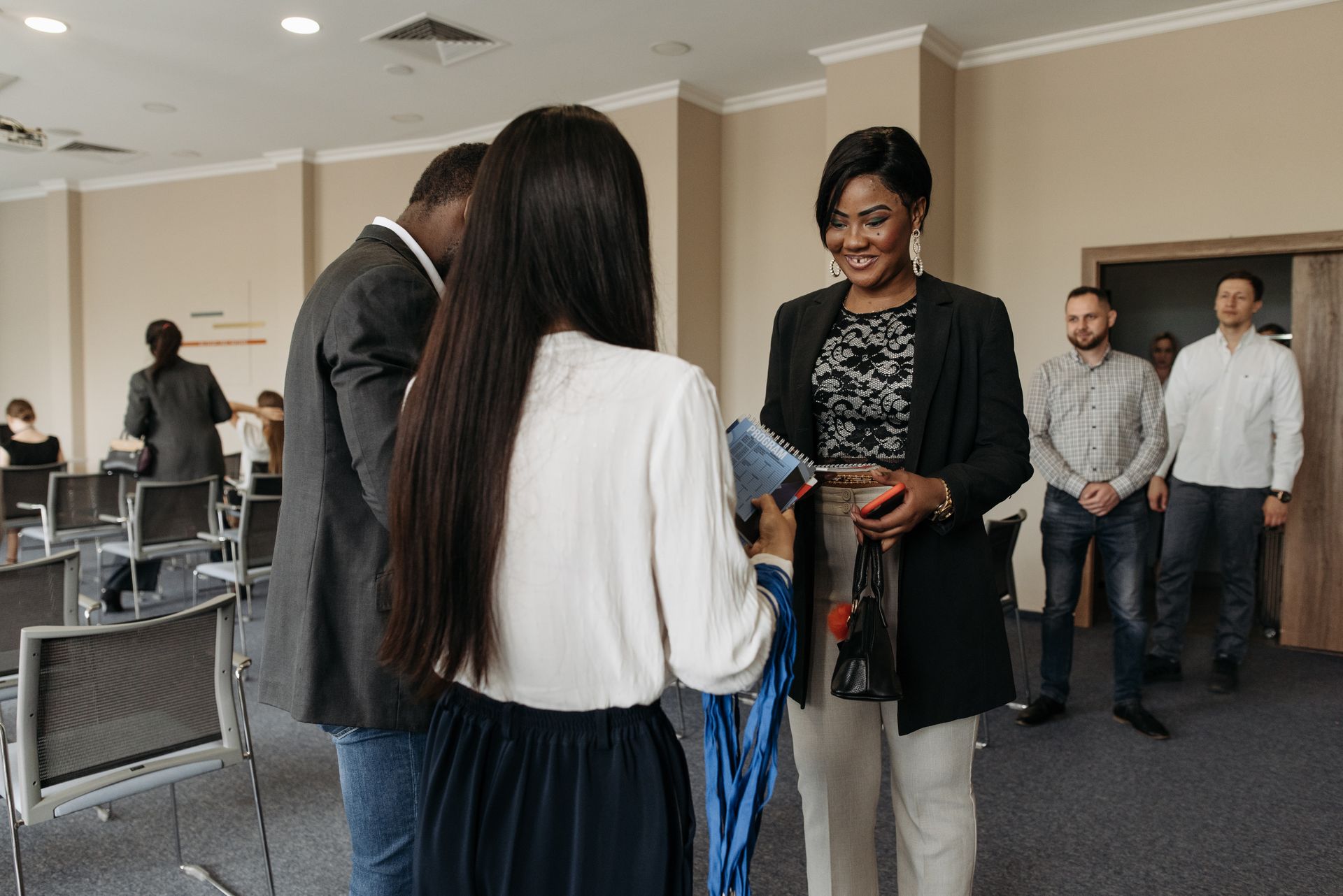 Three professionals exchange information at a job fair event.